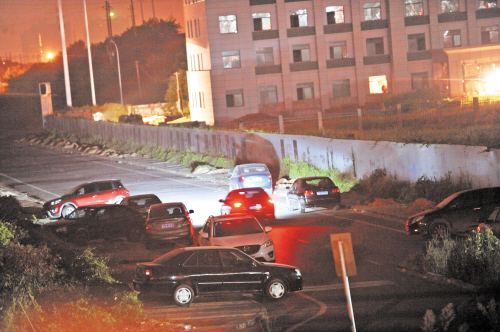 深夜，不少黑车聚集在火车南站公交车发车坪墙外。均为长沙晚报记者 小刘军 摄