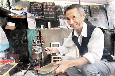 观音桥小苑三村，刘为忖的修补摊挂着谜语