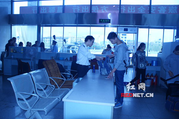 10月7日迎来“返程高峰”，湘乡火车站安检员正在安检