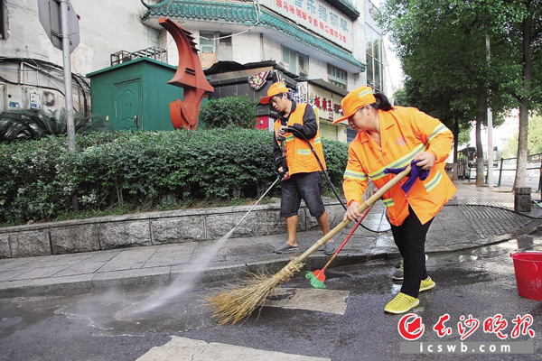 国庆长假第二天，解放东路，环卫工一大早就忙着铲除城市“牛皮癣”、擦护栏，确保城区主干道卫生清洁。 长沙晚报记者 陈飞 摄
