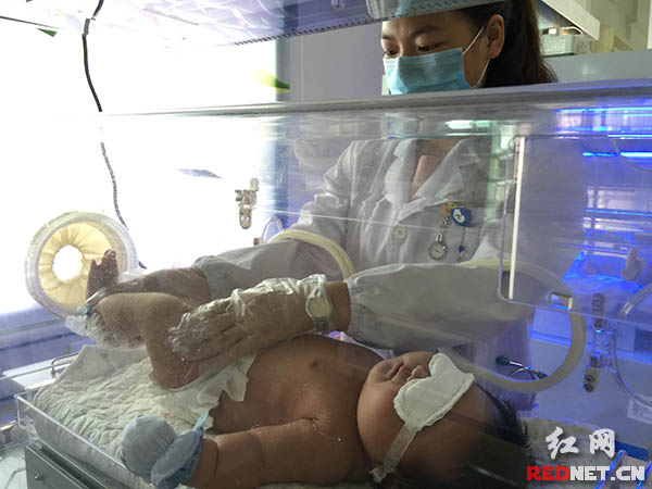 医生在给该宝宝检查身体。