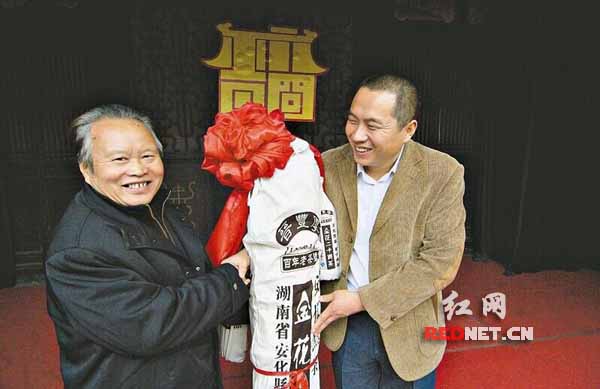 谌小丰[左]与他的金花千两茶。