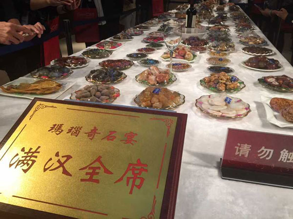 “新常态·新定位·新提升——第十一届中国网络媒体山东行”采访团记者在中国蓝宝石博物馆的玛瑙奇石宴“满汉全席”展厅采访。