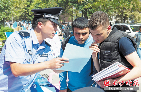 昨日上午，民警通过发放资料、防骗鼠标垫等，向大学生们讲解防范电信网络诈骗的知识。　　长沙晚报　　通讯员 王思鸽 摄