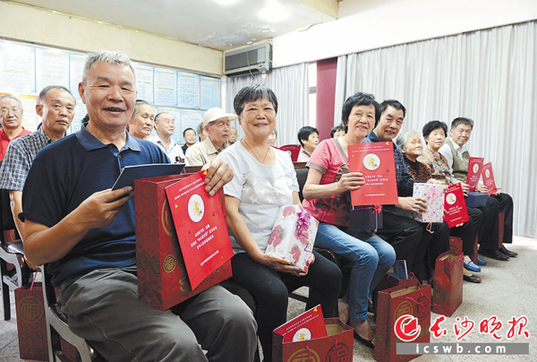 昨日，在开福区四方坪街道李家冲社区“孝心敬老周”重阳节系列活动中，辖区人大代表、街道及社区负责人向老人赠送保温杯、健康保险、免费体检卡和长寿面等。 长沙晚报记者 石祯专 摄