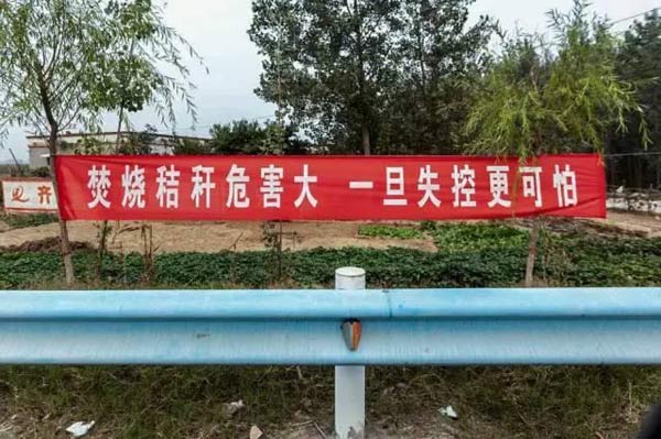 图为打击焚烧秸秆标语。