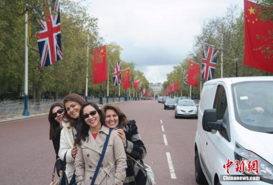 10月19日，中国国旗与英国国旗悬挂在英国伦敦白金汉宫前的林荫路两旁，人们在两国国旗前拍照留念。<a target='_blank' href='http://www.chinanews.com/'><p  align=