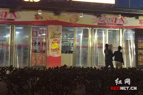 晚上8时许，湘潭步步高超市金海店门口，过路的行人扭头看着店里
