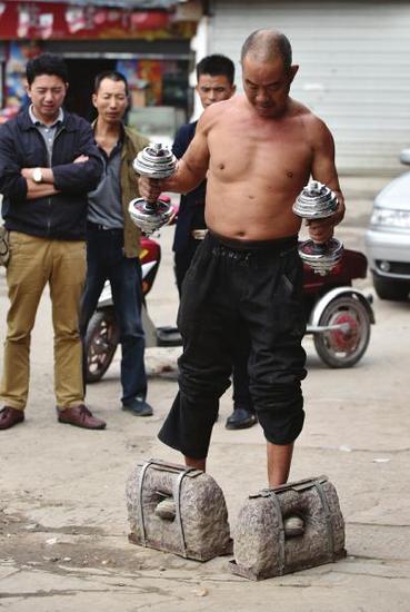 黄保全穿着百斤重的石鞋手举哑铃散步。