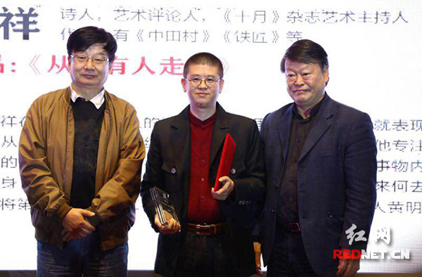 叶延滨（左）唐晓渡（右）为黄明祥（中）颁奖。