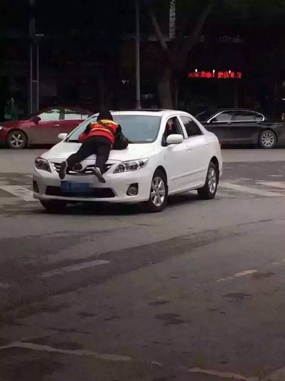 为收3元停车费5旬大妈趴车上要求车主交费（图）