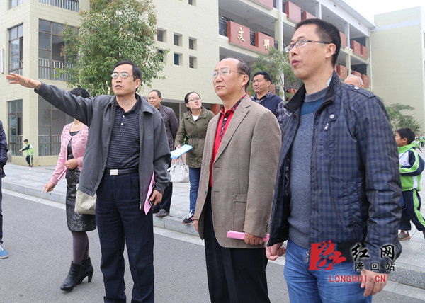 邵阳市人大常委会副主任蒋耀华（右二）参观隆回九龙学校抗震设防基础建设