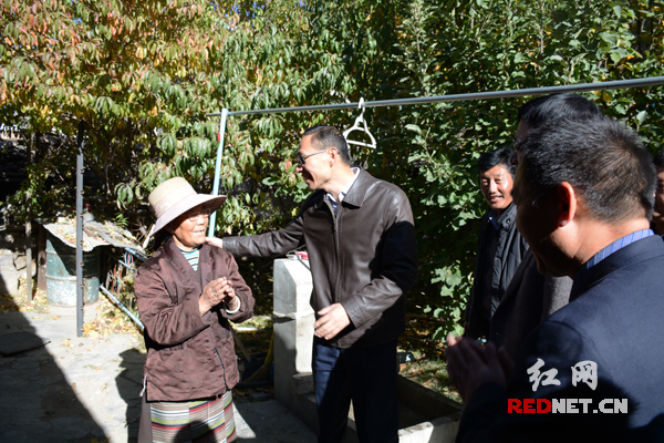 桑日县县委书记、岳阳市第七批援藏工作队领队孙志诚（左二）到旦增卓嘎家走访，他们在院子里寒暄起来。