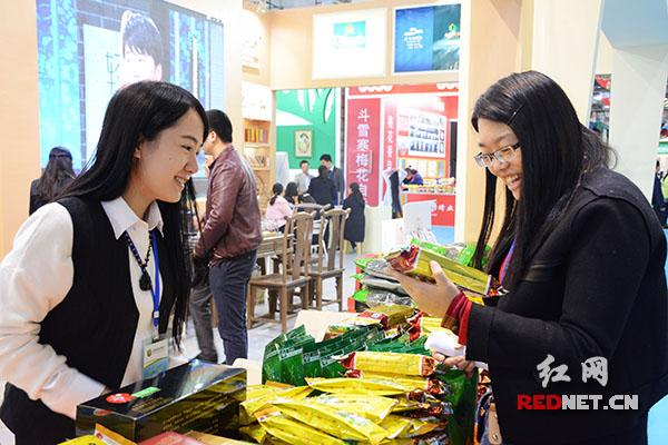一楼展区，湖南茶业集团工作人员正在给商户介绍产品。