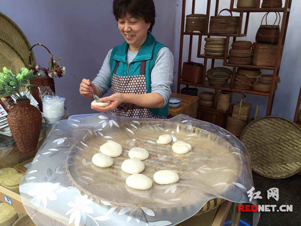 为竹艺区，四川的李阿姨在为市民朋友制作美味的糍粑。这是她第三次参加非遗文化节。