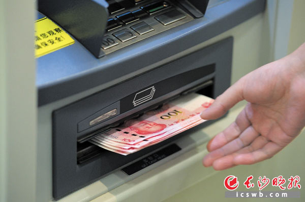 市民在银行ATM机上提取新版百元钞票。新华社发