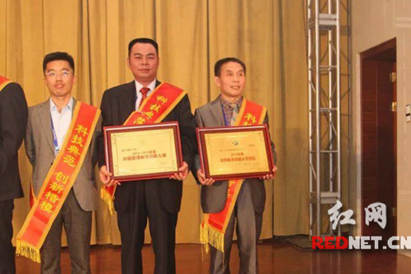 岳阳中医李穆（右）在全国科技创新先进个人颁奖台上。