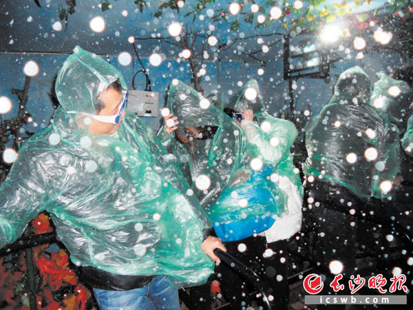 在台风体验馆内，“超强飓风”裹挟着雨水扑面砸来，人们被吹得东倒西歪，不得不用力抓好护栏。长沙晚报记者 周柏平 摄