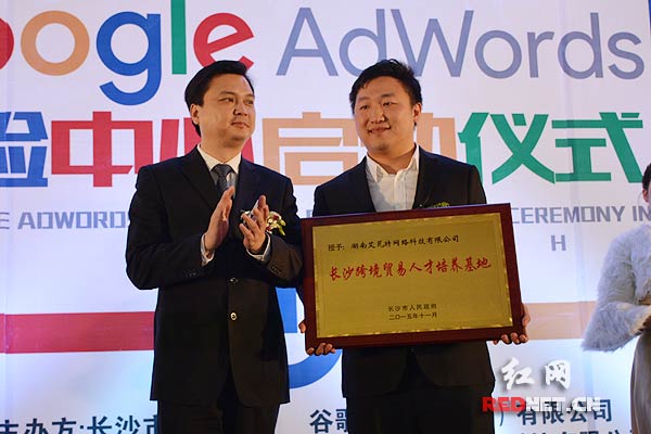 长沙市副市长廖健(左)向湖南艾瓦特网络科技有限公司授予“长沙跨境贸易人才培养基地”牌匾。
