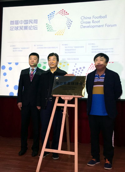 中国足协党委书记魏吉祥（中）为海口足球协会授牌。