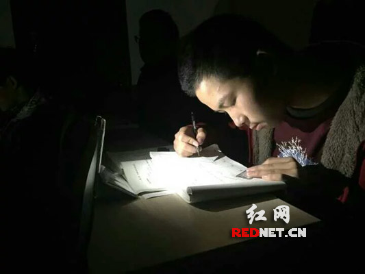长沙理工大学自习室停电，2015级学生在手机照明灯下继续自习，备战考试月。