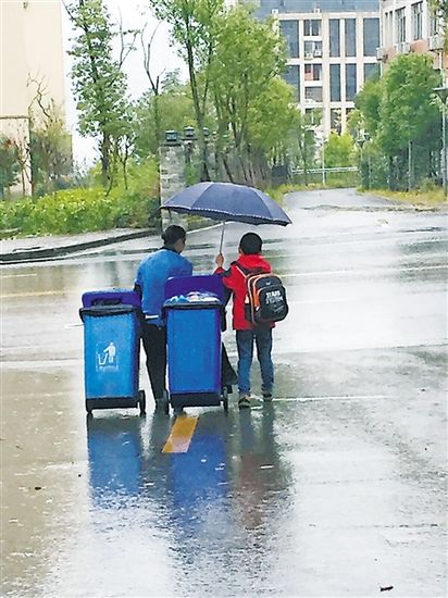 保洁员冒雨拖垃圾桶7岁男娃主动撑伞获赞（图）