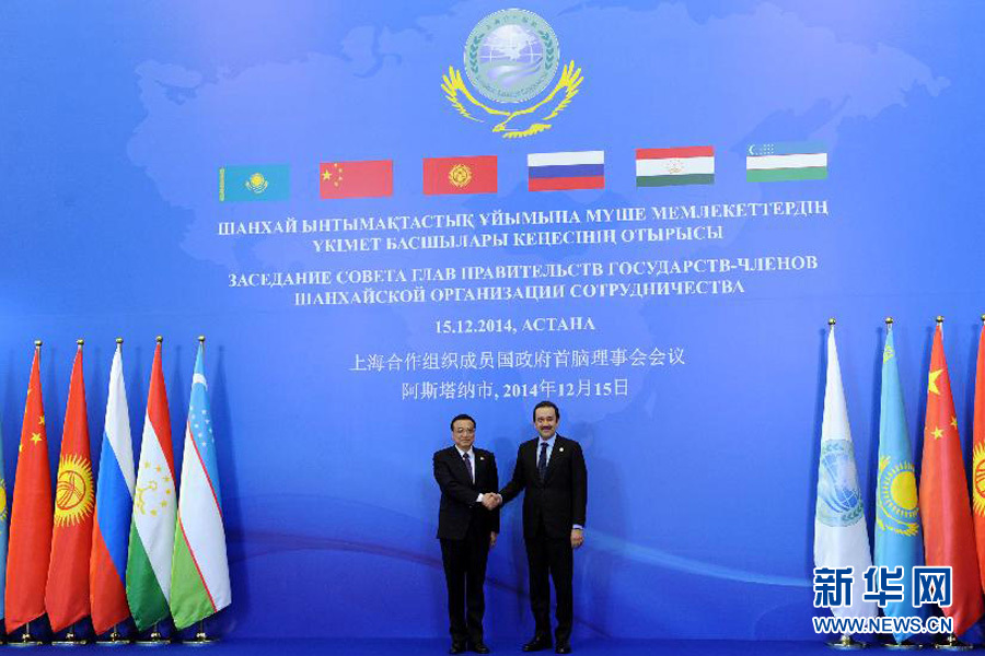 12月15日，中国国务院总理李克强在阿斯塔纳出席上海合作组织成员国政府首脑理事会第十三次会议。这是哈萨克斯坦总理马西莫夫迎接李克强。新华社记者 饶爱民 摄 