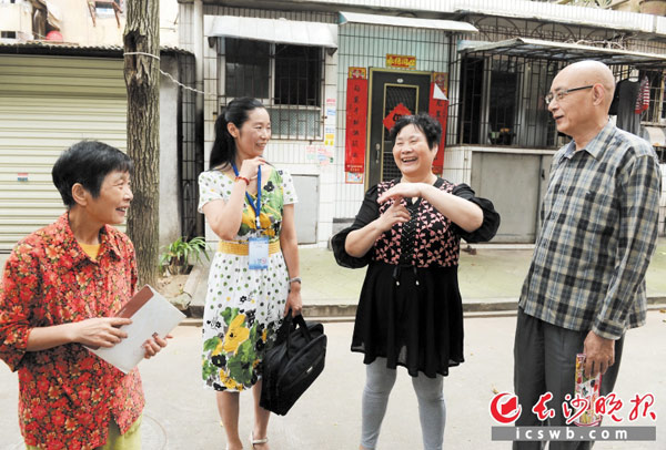 桐梓坡老5栋的居民夫妇任泽中（右一）和周玉芳（右二）对棚改政策表示满意，与工作人员和志愿者相谈甚欢。资料图片