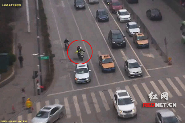 监控视频中，民警彭威正骑着摩托车载送求助者。