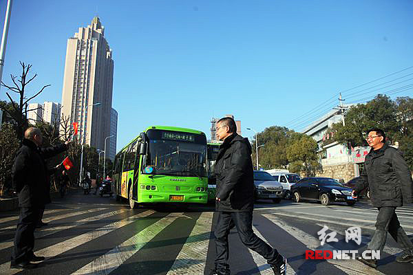 龙骧巴士交通监督员正督促公交车司机在斑马线前礼让市民，让市民在斑马线上从容通过。（资料图）