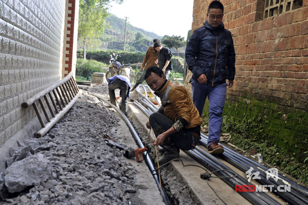 嘉禾县茂林村工人正在安装给水管道,目前全县273个行政村 (居委会)用上了自来水。