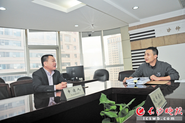 西藏一家矿业有限责任公司的董事长杨志(左)正在和长沙仲裁委员会调解员黄刚商谈调解事项。