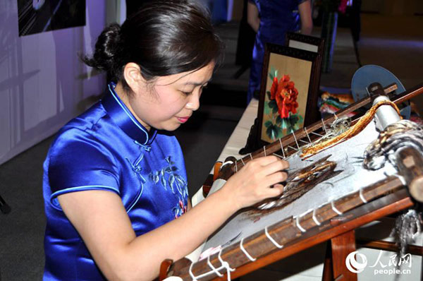 中国刺绣艺术大师成新湘女士在现场展示湘绣刺绣（殷淼 摄）。图片来源：人民网