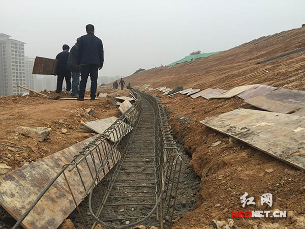 白马小学后的自然山体整改中设立排水沟防止雨水对山体冲刷，对山体表层进行固化。