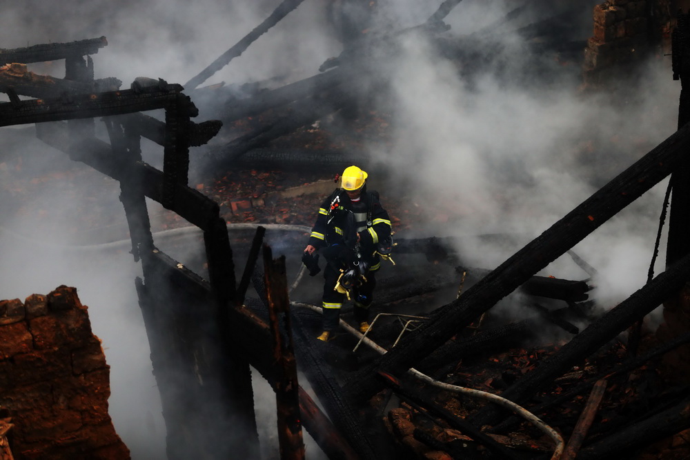 1月11日，消防人员在祠堂火灾现场灭火。 