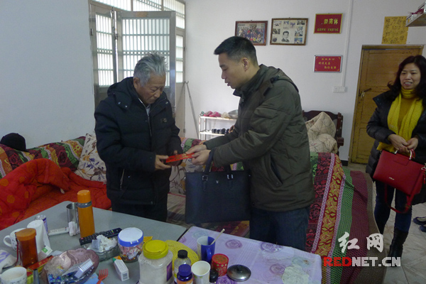 岳阳市云溪区国税局副局长易新平向离退休老干部送上慰问金。