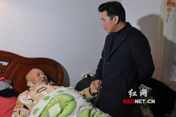 株洲市环保局党组书记、局长章文才正在鼓励病重职工杨卫农战胜病魔早日康复。