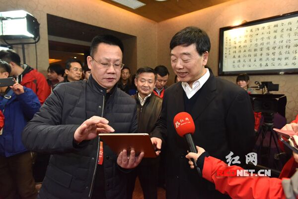 中南传媒董事、红网党委书记、董事长舒斌向于来山介绍省两会报道情况。