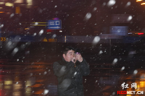 1月31日,长沙火车站,赶路的人停下脚步,用手机记录下这场姗姗来迟的大雪。