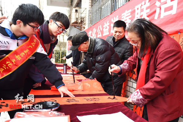 爱心书画艺术家挥毫泼墨，为市民免费送春联。
