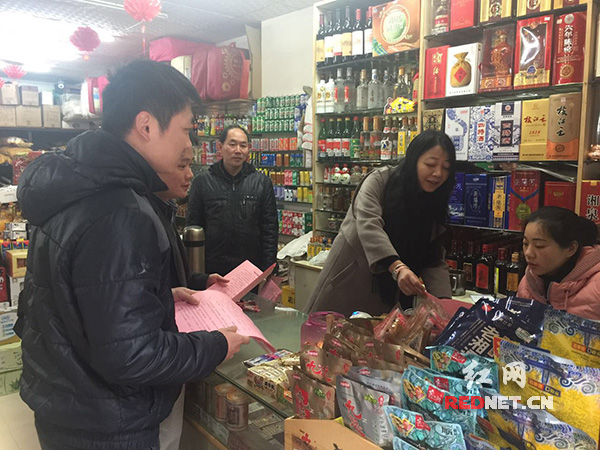 志愿者向店铺经营人员发放“治污清霾从我做起”倡议书。