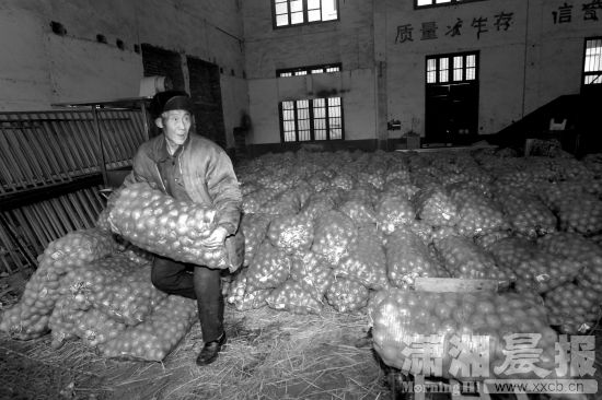 2月1日,长沙东瓜山,76岁的麻阳人张王汉搬运冰糖柑 给上门的顾客。图/记者华剑