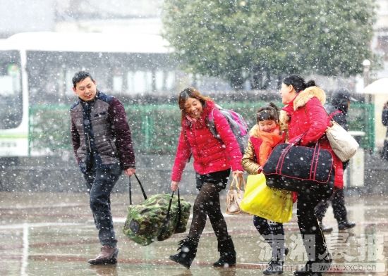 2月1日，长沙火车站，提着行李在风雪中行走的旅客。图/摄友团钟锡发