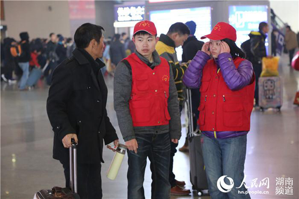 志愿者正在帮助前来咨询的旅客