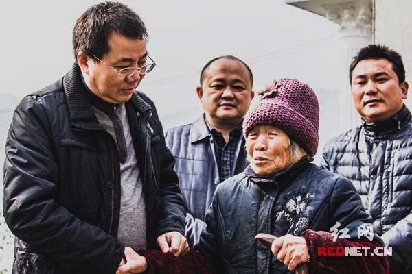 钟贵荣(左一)与立马村困难村民聊家常。