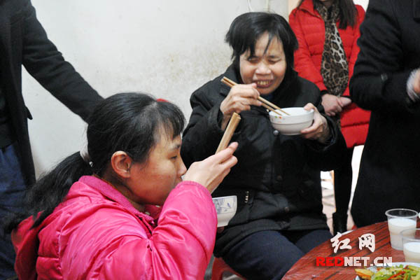 吃着社区工作人员亲手烹制的团圆饭，汤建华母女喜笑颜开。