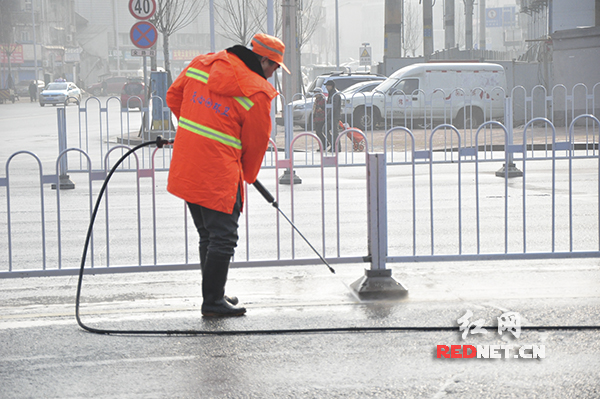 一名环卫工人在清扫路面和护栏。