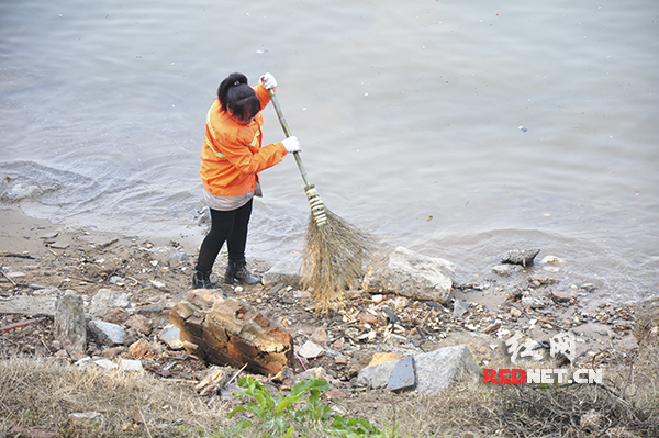 一名环卫工人正在湘江边沿湘江风光带清扫，大多是游客留下的包装袋、烟头、槟榔壳等垃圾。