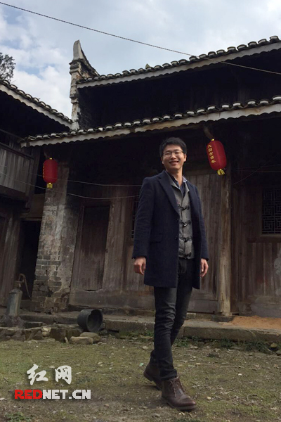 站在自家老宅旁的杨祖灯。