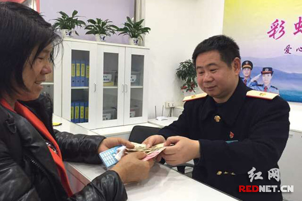 刘大妈在值班站长朱勇的帮助下取到200元现金。